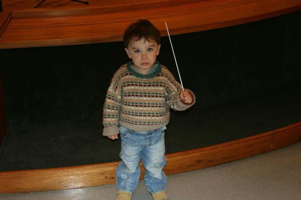 Benjamin as a young child holding a conductor’s baton