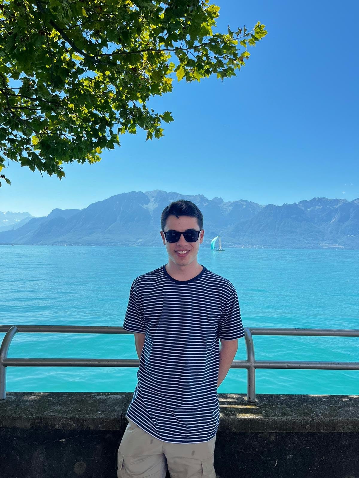 Benjamin Carter beside a turquoise lake with mountains behind him